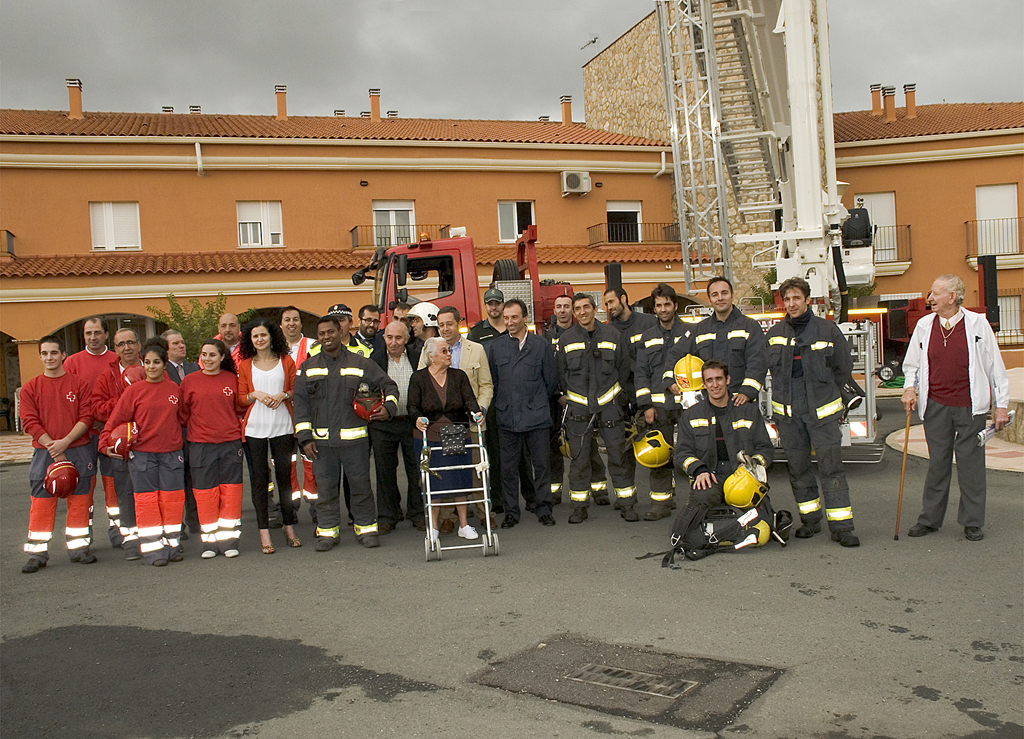 Grupo de bomberos y sanitarios en una residencia con gente con alguna discapacidad en las puertas de una residencia.