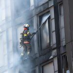 Bombero en un edificio en altura extinguiendo un fuego