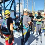 Obrero con cascos blancos y amarillos aprendiendo como se hacen los trabajos en altura