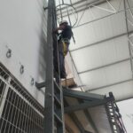 Operario subido a una escalera haciendo trabajos en altura